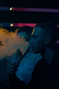 Man smoking hookah in a dimly lit room