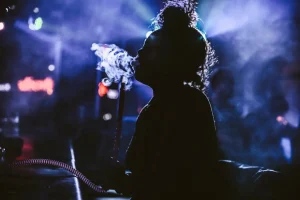 Woman smoking hookah in vibrant setting