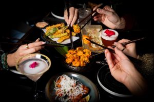 Group dining with sushi and cocktails