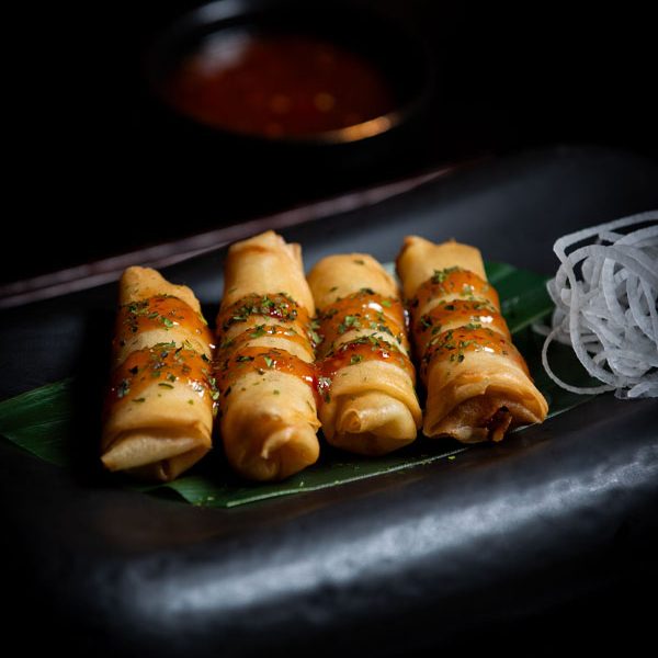 Delicious spring rolls served with sauce